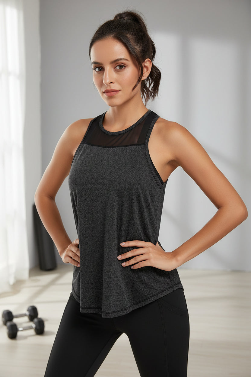 Woman wearing a dark gray tank top with mesh back in a gym setting
