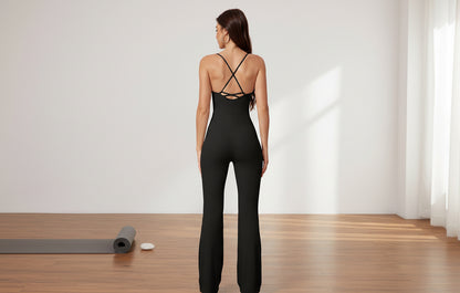Woman wearing a black jumpsuit with criss-cross straps in a yoga setting