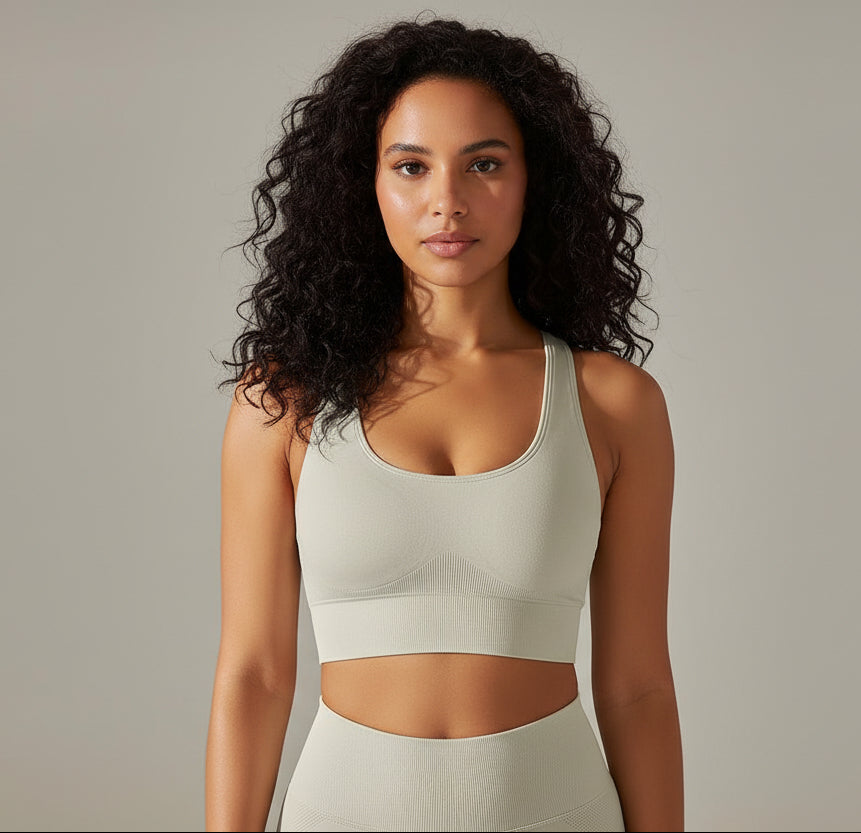 Woman wearing a Beige sports bra and leggings against a neutral background