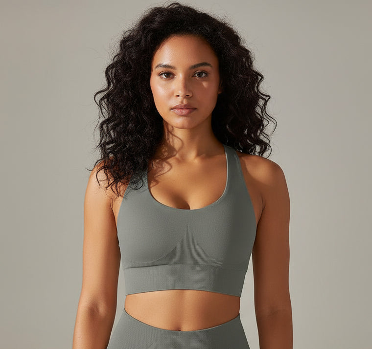 Woman wearing a gray sports bra against a neutral background