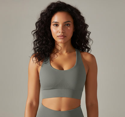 Woman wearing a gray sports bra against a neutral background