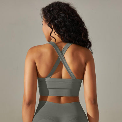 Woman wearing a gray sports bra and leggings against a neutral background