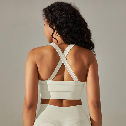 Woman wearing a white sports bra and leggings against a neutral background