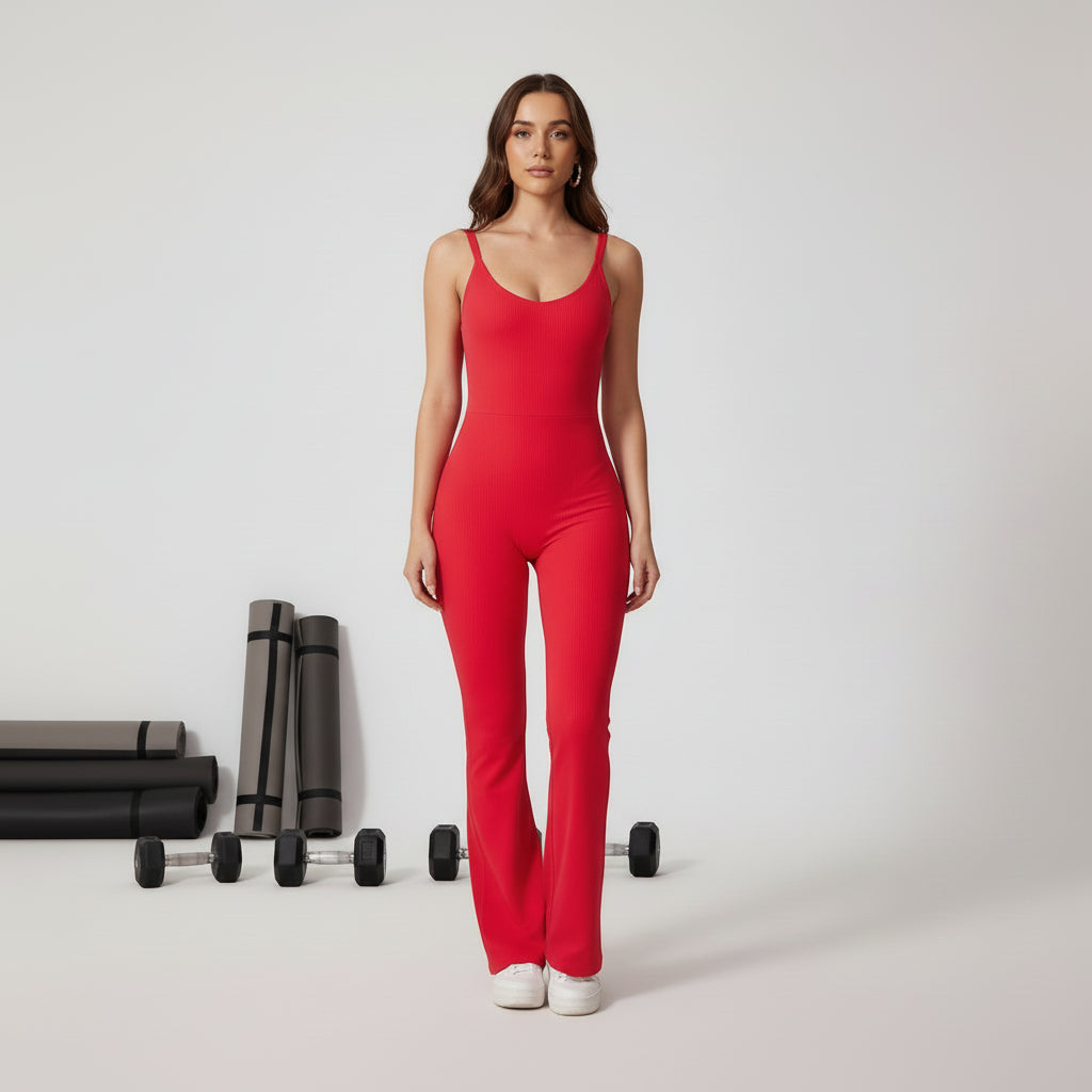 Woman wearing a red jumpsuit in a gym with dumbbells and mats