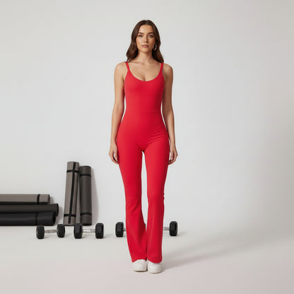 Woman wearing a red jumpsuit in a gym with dumbbells and mats