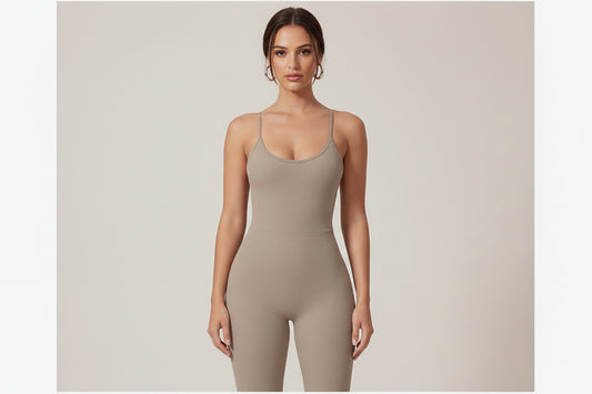 Woman wearing a beige bodysuit with strappy back design on a light gray background